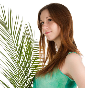 Beautiful young woman on the background of robelini leaves