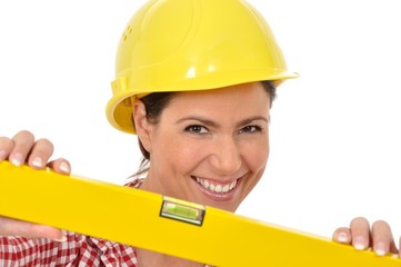 Obraz na płótnie Canvas Handwerkerin mit Helm hält eine gelbe Wasserwaage in die Kamera