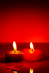 Fototapeta na wymiar Two burning heart shaped candles