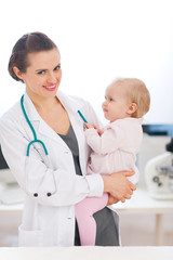 Happy pediatrician doctor with baby on examination