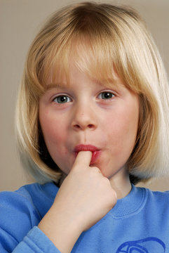 Ni&ntilde;a comiendo chocolate chupando dedos.