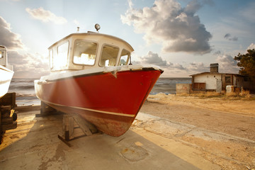 Boat in parking lot on the background of beautiful sunset