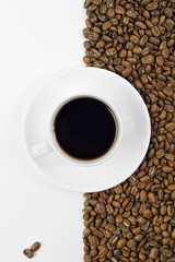 Koffie in witte kop op schotel geplaatst op achtergrond van koffie bea