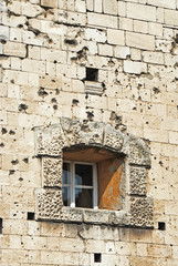 Shattered wall with cracks and bullet holes