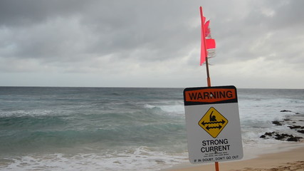 A warning sign at a stormy beach