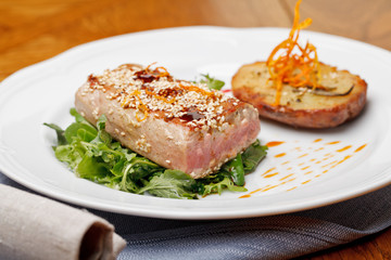 Fried tuna steak and potatoes on the plate