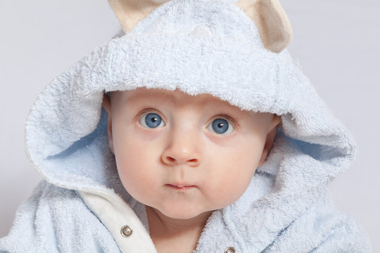 portrait of a cheerful child in blue bathrobe
