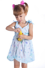 Pretty little girl in a blue dress with a banana in her hands