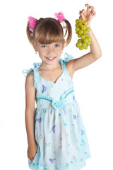 Pretty little girl with green grapes in her hand