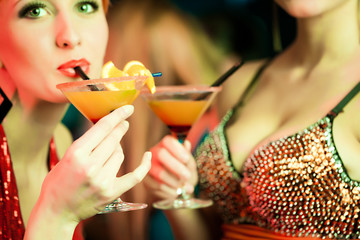 Frauen in einem Club trinken Cocktails