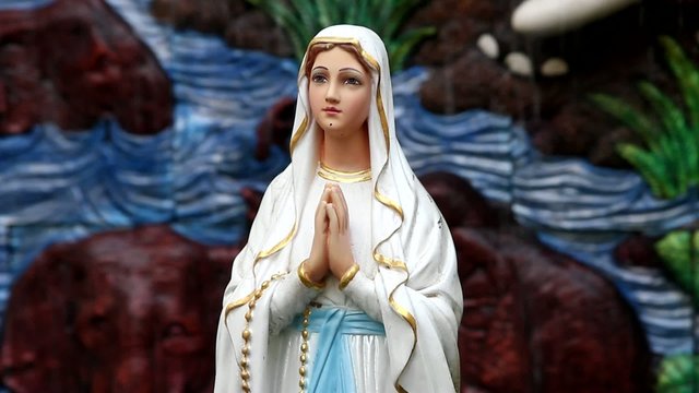 A praying virgin mary statue with  fountain