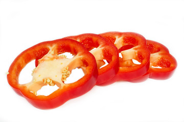 In Ringe geschnittene rote Paprika auf weißem Hintergrund