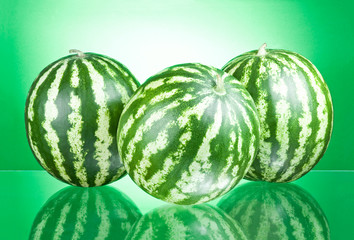 Three Watermelons isolated on a green background