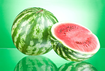 Watermelon and half on a green background