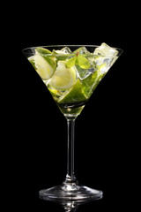glass of cocktail with lime and mint on black background