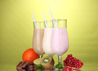 Milk shakes with fruits and chocolate on green background
