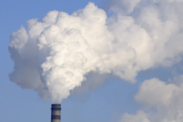 Industrial Smokestack with Heavy Smoke on Blue Sky Background