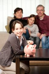 young girl  with her parents saving money on a piggy bank