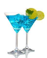 Blue cocktail in martini glasses with ice isolated on white
