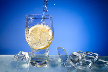 Water, ice and lemon in glass