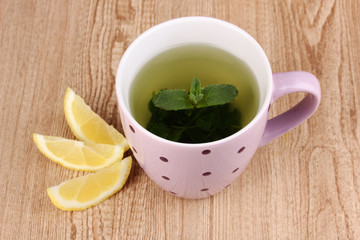 Mint tea with mint leaf and lemon on wooden background