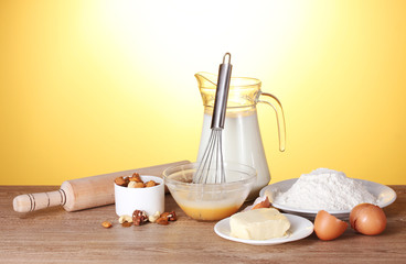 Ingredients for the dough wooden table on yellow background
