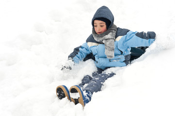 Fototapeta na wymiar Young boy having fun sliding in the snow.