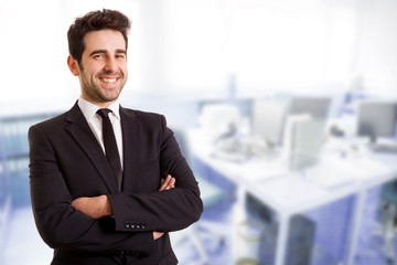 Closeup of a young smiling business man standing at his office