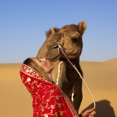 Young women wearing a saree and kissing a camel