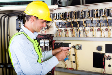 electrician changing industrial machine switch