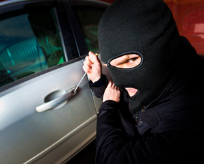 robber and the thief in a mask hijacks the car
