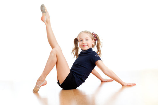 young pretty girl doing gymnastics on floor