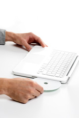 Businessman inserting a cd on white laptop