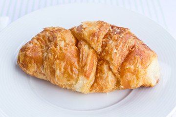 The fresh croissant isolated on white plate