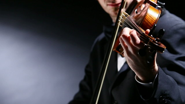 the violinist: Musician playing violin on dark background