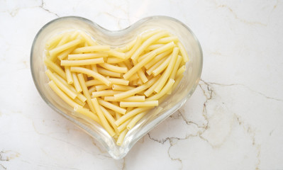 Italian noodle, pasta maccheroni, in a heart shaped glass bowl