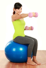 Fototapeta na wymiar exercising with dumbbells and pilates ball