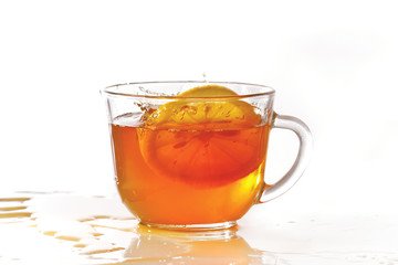 Cup of ice tea and lemon with splash on a white background