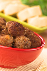 Meatball appetizers in a bowl with baguette slices