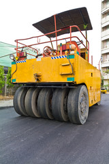 Steamroller on asphalt road from back