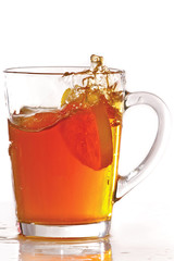 Cup of ice tea and lemon with splash on a white background