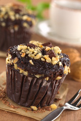 Chocolate-walnut muffins with coffee cup in the back