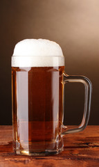 beer mug on wooden table on brown background