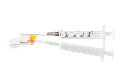 Syringe and tablets isolated on white
