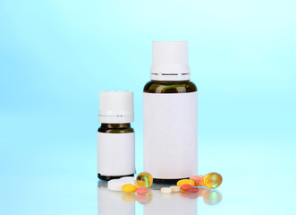 Medical bottles and tablets on blue background