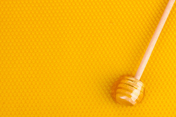 yellow beautiful honeycomb and wooden honey drizzler with honey