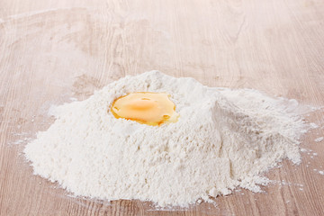 egg in flour on wooden table
