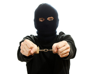 Bandit in black mask handcuffed isolated on white