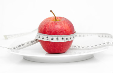 Apfel mit Massband auf Teller