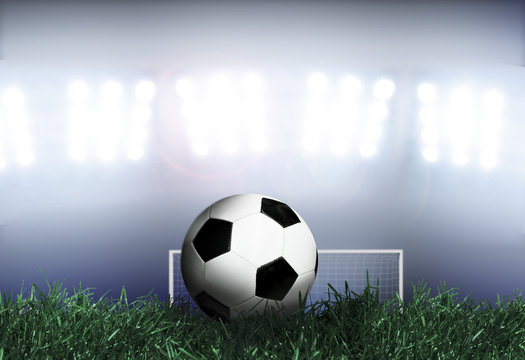 Soccer ball on grass field with spotlights